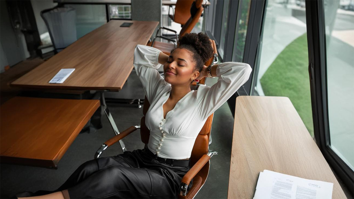 Woman in an office chair with her hands behind her head and eyes closed embodies the peace of mind offered by luxury Airbnb co-hosting and short-term rental management by a Hampton Roads property manager for vacation home owners.